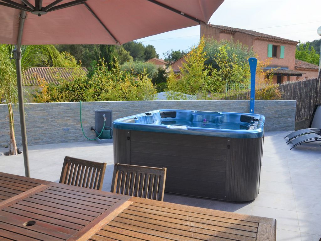 Spa de hidromasaje instalado en una terraza con sombrilla
