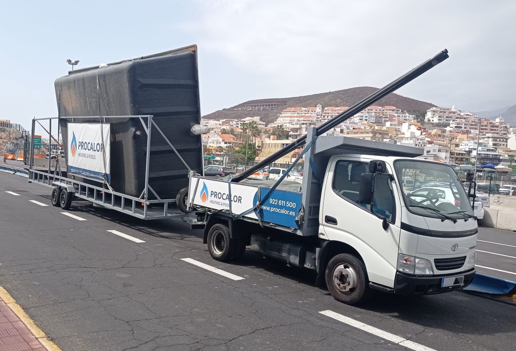 Camión de PROCALOR con remolque cargado con una piscina compacta, en el puerto de Los Cristianos (Tenerife)