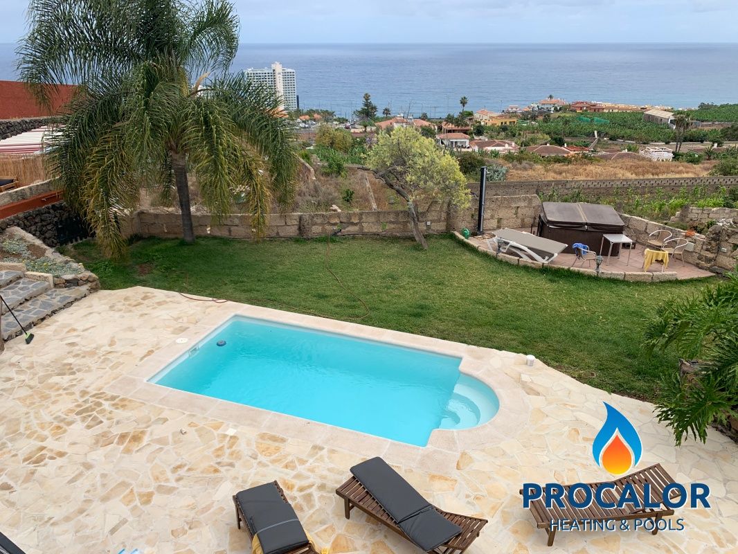 Piscina compacta con solárium y palmeras frente al mar, instalada por PROCALOR